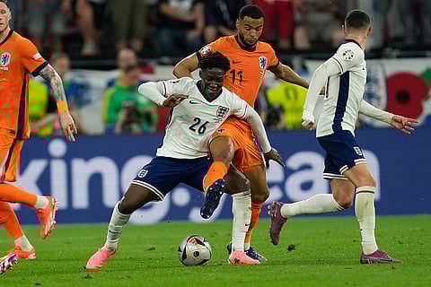 Kobbie Mainoo is challenged by Cody Gakpo